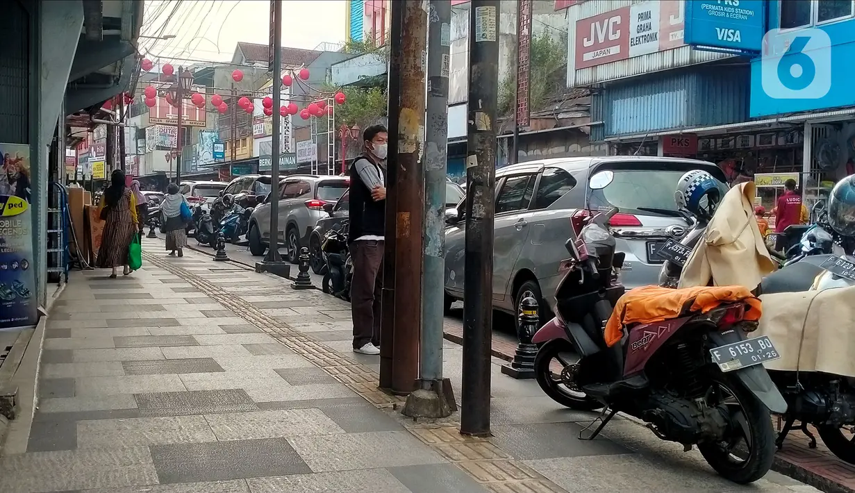 Sejumlah tiang berdiri di jalur disabilitas pedestrian sepanjang Jalan Surya Kencana, Kota Bogor, Jawa Barat, Sabtu (3/12/2022). Jalur pedestrian yang seharusnya menjadi akses pejalan kaki dan ramah bagi kaum disabilitas itu tidak berfungsi dengan semestinya. (Liputan6.com/Magang/Aida Nuralifa)