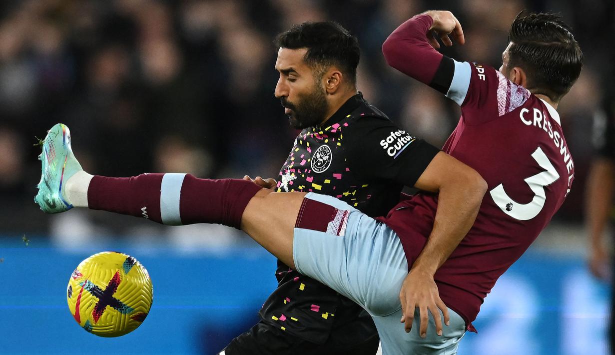 Pesepak bola asal Iran, Saman Ghoddos (kiri) saat ini tengah menjalani musim keempat bersama Brentford, dan turut membawa The Bees promosi ke Premier League pada awal musim 2021/2022. Di Premier League sendiri, memasuki musim keduanya ia telah bermain dalam 32 laga bersama Brentford dengan raihan 1 gol dan 2 assist. (AFP/Ben Stansall)