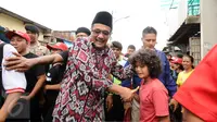 Cawagub petahana, Djarot Syaiful Hidayat menyalami seorang anak saat sosialisasi di kawasan Pademangan VIII, Jakarta, Kamis (23/3). Selain sosialisasi dengan warga, Djarot juga menyerap keluhan warga sekitar. (Liputan6.com/Helmi Fithriansyah)  