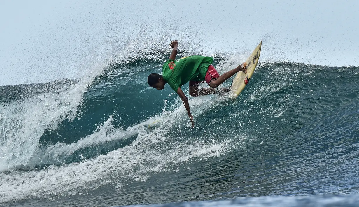 Seorang peselancar mengikuti kompetisi selancar di pantai Lhoknga, Provinsi Aceh (26/2/2022). Kompetisi ini sekaligus sebagai upaya untuk menarik serta meningkatkan kunjungan wisatawan di kabupaten itu. (AFP/Chaideer Mahyuddin)