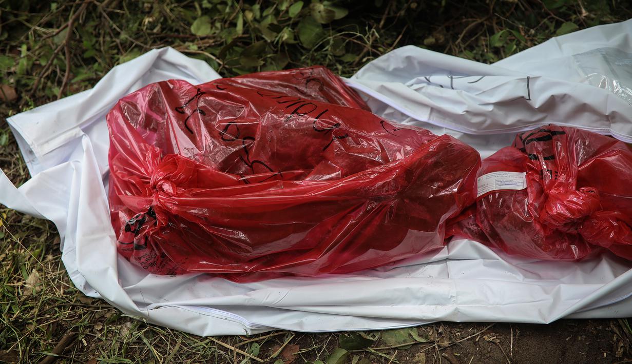 Sisa-sisa manusia ditempatkan di tas merah yang digali dari kuburan massal rahasia di negara bagian Veracruz, Meksiko, Jumat (7/9). Ini bukan yang pertama polisi mendapat informasi dari masyarakat terkait lokasi kuburan massal. (AP/Felix Marquez)