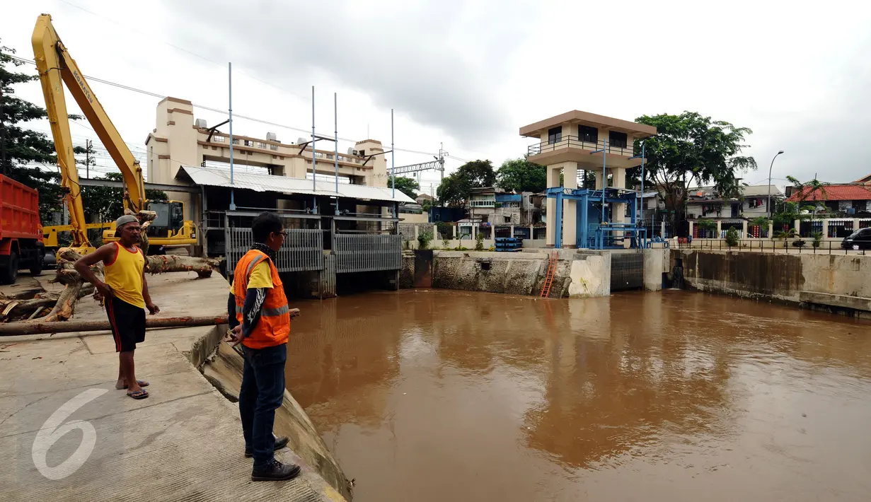 Petugas melihat ketinggian air di pintu air Manggarai, Jakarta, Kamis (11/2/2016). Volume air di Pintu Air Manggarai masih sekitar 690 cm (normal) meski hujan mengguyur sebagian Jakarta dan Bogor sepanjang Kamis (11/2). (Liputan6.com/Helmi Fithriansyah)