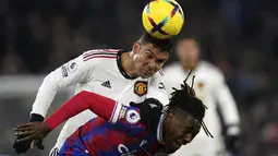 Gelandang Manchester United (MU) Casemiro berebut bola dengan penyerang Crystal Palace Wilfried Zaha ada matchday 19 Liga Inggris di Stadion Selhurst Park, London, Kamis dini hari WIB (19/1/2023). Kemenangan yang sudah di depan mata sirna setelah Crystal Palace berhasil mencetak gol balasan di menit-menit akhir pertandingan. (Adam Davy/PA via AP)