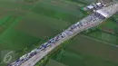 Sejumlah kendaraan terjebak kemacetan saat keluar tol Pejagan, Jawa Tengah, Sabtu (2/7). Kemacetan panjang hingga 18 km terjadi dikarenakan antrean saat pembayaran pintu tol keluar. (Liputan6.com/Balgo Marbun)