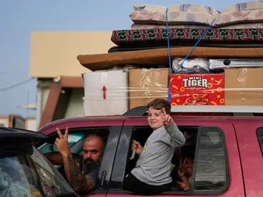 Para pengungsi mengacungkan tanda kemenangan di Qasmiyeh dekat kota Tyre, Lebanon Selatan, saat mereka kembali ke desa mereka setelah gencatan senjata antara Hizbullah dan Israel, Jumat 17 April 2026. Warga Lebanon mulai bergerak kembali ke rumah dan desa mereka, terutama di wilayah selatan, menyusul diumumkannya kesepakatan gencatan senjata sementara selama 10 hari antara Israel dan Hizbullah. (AP Photo/Mohammed Zaatari)