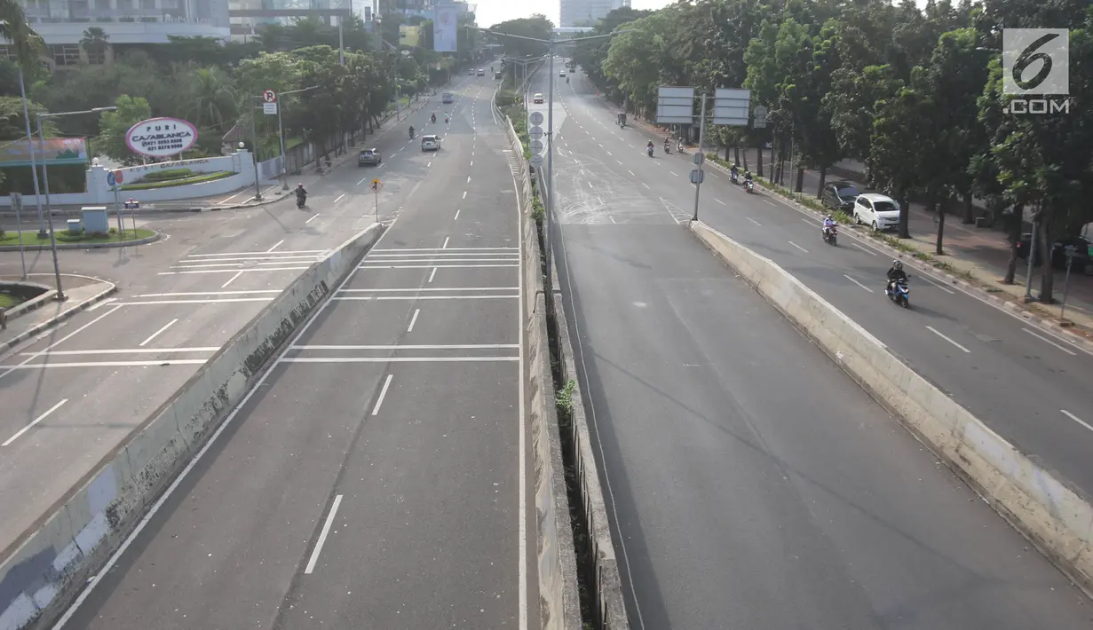 Sejumlah kendaraan melintas di Jalan Thamrin, Jakarta, Jumat (15/6). Pada Hari Raya Lebaran hari pertama, sejumlah ruas jalan di Jakarta tampak sepi dan lengang, berbeda dengan kondisi normal yang padat dan macet. (Liputan6.com/Arya Manggala)