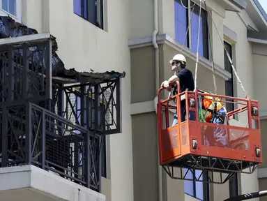 Pekerja memeriksa kerusakan balkon di lantai 4 dari sebuah apartemen yang runtuh, di California, AS, 16 Juni 2015. Enam orang mahasiswa yang berada di balkon itu dikabarkan terjatuh dan tewas. (REUTERS/Elia Nouvelage)