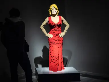 Seseorang berdiri di dekat patung "Courtney Red" yang terbuat dari susunan balok lego pada pameran Art of the Brick di Turin, Italia, Kamis (15/11). Pameran tersebut menampilkan berbagai patung lego karya seniman AS, Nathan Sawaya. (MARCO BERTORELLO/AFP)