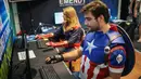 Cosplayer berkostum ala karakter Captain America dan Captain Marvel bermain video game dalam acara Comic Con Africa di Johannesburg, Sabtu (21/9/2019). Comic Con Africa untuk tahun kedua di benua itu  akan berlangsung selama empat hari dari 21 hingga 24 September. (Michele Spatari/AFP)