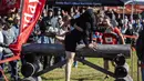 John Lund menggendong Karen May melewati rintangan selama North American Wife Carrying Championship di Sunday River Resort di Newry, Maine, pada 8 Oktober 2022. Kejuaraan ini seakan menguji pengorbanan para suami yang rela menggendong istrinya dengan melewati berbagai rintangan. (Joseph Prezioso / AFP)