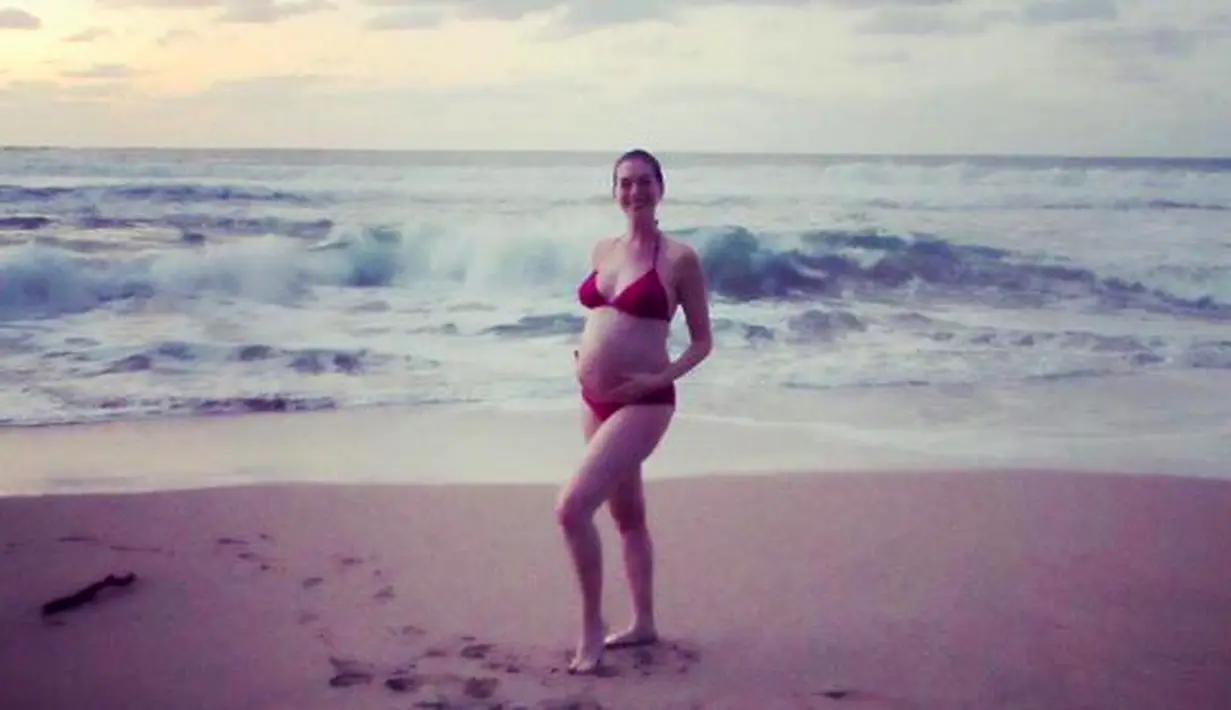 Bintang Les Miserables, Anne Hathaway memamerkan baby bump-nya saat dipantai. Istri dari Adam Shulman, yang dinikahi 2012 silam itu mengucapkan selamat tahun baru. Foto itu diunggah awal tahun ini. (Istimewa)