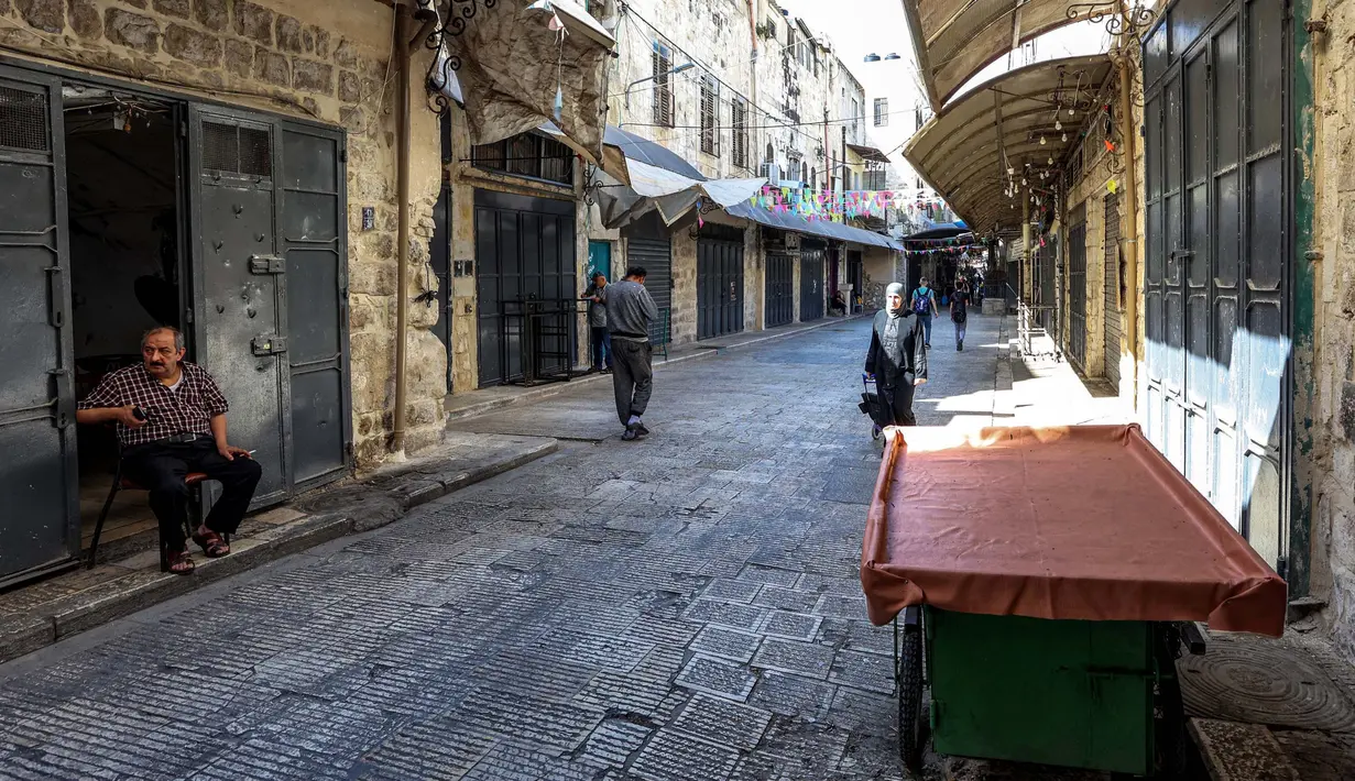 Orang-orang berjalan melewati toko-toko yang tutup menyusul seruan pemogokan umum untuk mendukung warga Palestina di Jalur Gaza, di kota Nablus di Tepi Barat, pada 25 Oktober 2023. (Zain JAAFAR/AFP)
