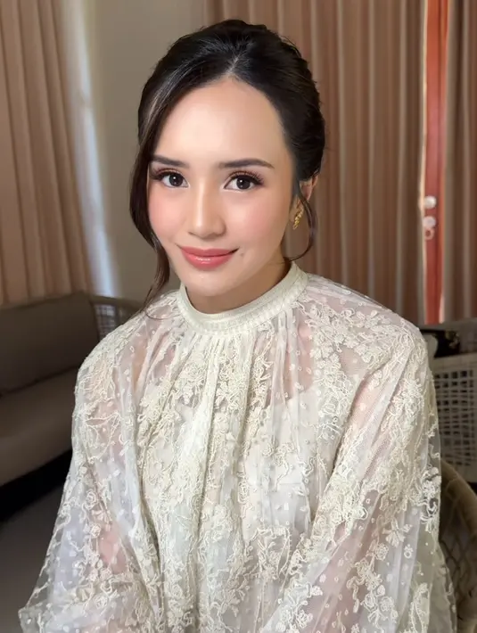 Wajah putihnya pun dipoles bernuansa pink, dengan blush on dan lipstik glossy yang dikenakan. Riasan mata pun dibuat lebih soft. [@fidelhertamakeup]