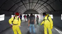 Para penumpang kapal yang memasuki Pelabuhan Pelabuhan ASDP Ketapang Banyuwangi diwajibkan melalui ”terowongan” disinfeksi.