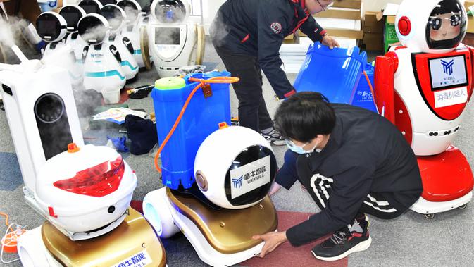 Para teknisi menyetel robot desinfeksi di sebuah perusahaan teknologi di Qingdao, Provinsi Shandong, China, 11 Februari 2020. Beberapa robot desinfeksi ini telah digunakan di ruang isolasi sejumlah rumah sakit di China. (Xinhua/Li Ziheng)