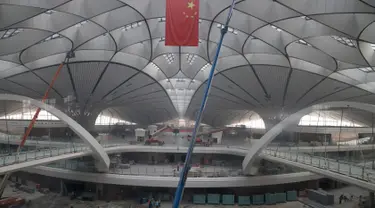 Sebuah bendera nasional Tiongkok digantung di terminal Bandara Internasional Beijing Daxing yang sedang dibangun di pinggiran Beijing, China (1/3). Bandara baru di ibu Kota China ini akan menjadi salah satu yang terbesar di dunia. (AP Photo/Ng Han Guan)