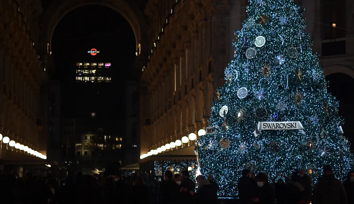 Orang-orang melewati pohon Natal raksasa di Galleria Vittorio Emanuele II di Milan, Italia, pada 7 Desember 2020. Italia mencatat 13.720 infeksi baru Covid-19 pada Senin (7/12) dan merupakan penambahan harian terendah sejak 20 Oktober lalu, yang mencapai 10.874 infeksi baru. (Xinhua/Daniele Mascolo)