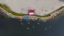 Foto udara memperlihatkan para penggemar kayak sedang mengibarkan bendera Merah Putih sebagai bagian dari perayaan Hari Ulang Tahun (HUT) ke-78 Republik Indonesia (RI) di sebuah pulau kecil di Teluk Jakarta, Jakarta, Kamis (17/8/2023). (BAY ISMOYO/AFP)