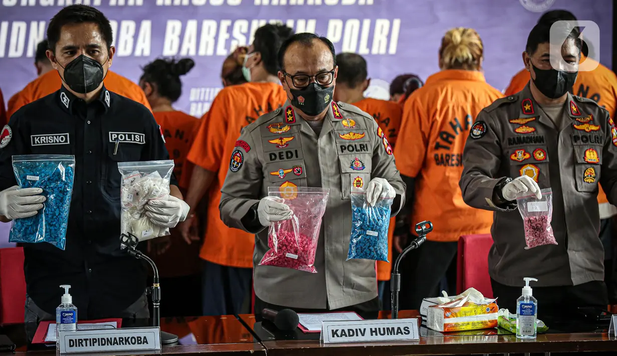 Direktur Tindak Pidana Narkoba Bareskrim Polri Brigjen Krisno Halomoan Siregar (kiri) menunjukkan barang bukti saat rilis kasus narkoba jaringan internasional di Gedung Bareskrim Mabes Polri, Jakarta, Kamis (11/8/2022). Menurut Direktur Tindak Pidana Narkoba Bareskrim Polri Brigjen Krisno Halomoan Siregar, peredaran narkoba dalam negeri terdapat di Medan, Jakarta, Bandung, Cirebon, Surabaya, dan Bali. (Liputan6.com/Faizal Fanani)