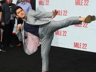 Bintang laga, Iko Uwais memamerkan gerakan pencak silat ketika menghadiri acara gala premier film Mile 22 di Los Angeles, Kamis (9/8). Iko Uwais tampil dalam balutan setelan jas abu-abu yang dipadukan dengan kaus warna gelap. (Jordan Strauss/Invision/AP)