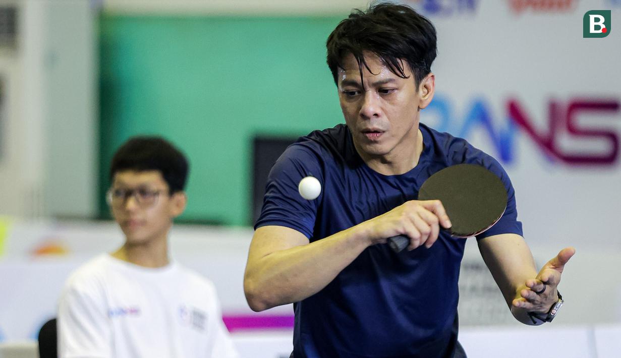 Ariel Noah berusaha mengembalikan bola ke arah lawannya, Desta pada laga dadakan tunggal putra Turnamen Olahraga Selebriti Indonesia (TOSI) season 2 di GOR POPKI Cibubur, Jakarta Timur, Sabtu (13/01/2024). Ariel Noah kalah 0-2 (18-21, 19-21). (Bola.com/Bagaskara Lazuardi)