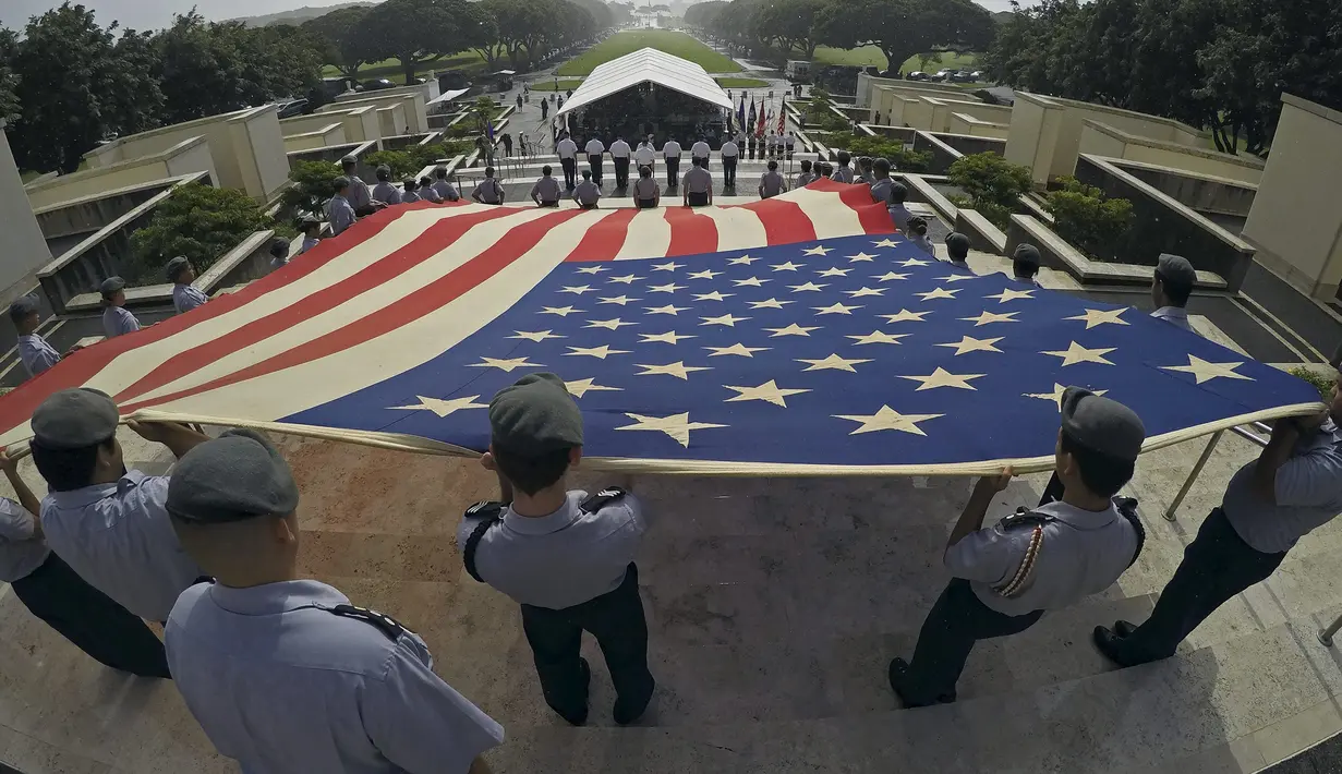 Anggota program Kahuku SMA Junior Cadangan Officer Training Corps (JROTC) membentangkan bendera nasional Amerika saat upacara peringatan Hari Veteran di Memorial Cemetery Nasional Pasifik di Honolulu, Hawaii, Rabu (11/11). (REUTERS/Hugh Gentry)