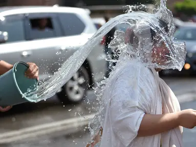 Orang-orang saling memercikkan air di pusat kota Yerevan selama liburan tahunan Vardavar pada 16 Juli 2023. (Photo by Karen MINASYAN / AFP)