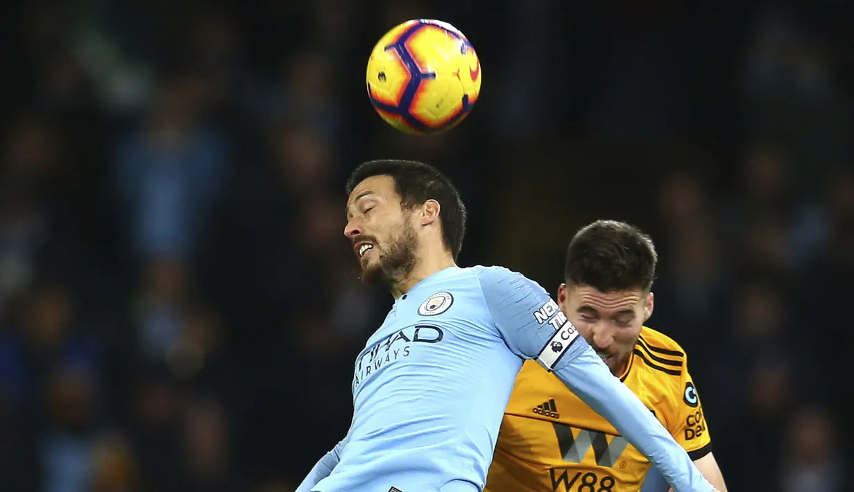 Gelandang Manchester City, David Silva, duel udara dengan pemain Wolverhampton Wanderers, Matt Doherty, pada laga Premier League di Stadion Etihad, Manchester, Senin (14/1). Manchester City menang 3-0 atas Wolverhampton Wanderers. (AP/Dave Thompson)