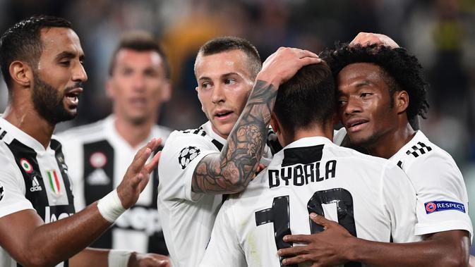 Pemain Juventus, Paulo Dybala (dua kanan) memeluk rekan setimnya usai mencetak gol ke gawang Young Boys dalam Grup H Liga Champions di Stadion Allianz, Turin, Italia, Selasa (2/10). Juventus membungkam Young Boys 3-0. (Miguel MEDINA/AFP)