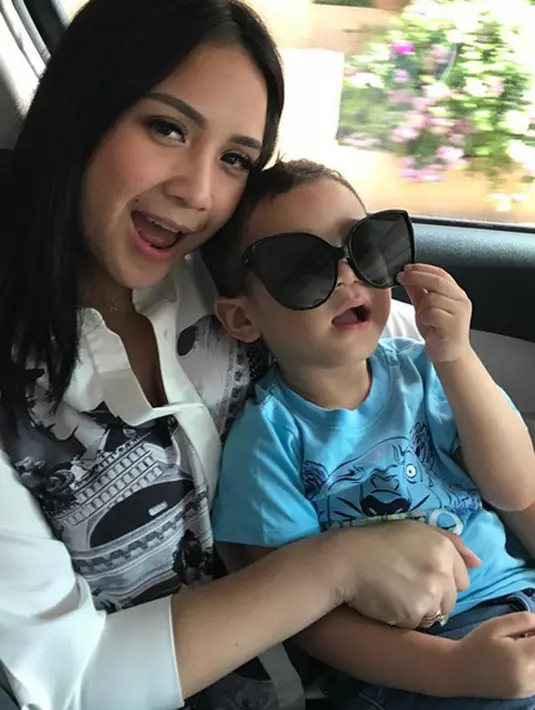 Nagita Slavina dan Rafathar sepertinya tak pernah terpisahkan ya? Di mana ada Nagita, di situ pasti ada Rafathar. Di foto ini Rafathar yang lagi bergaya dengan kaca mata hitamnya nyaman banget di pangkuan sang mama. (Instagram/raffinagita1717)