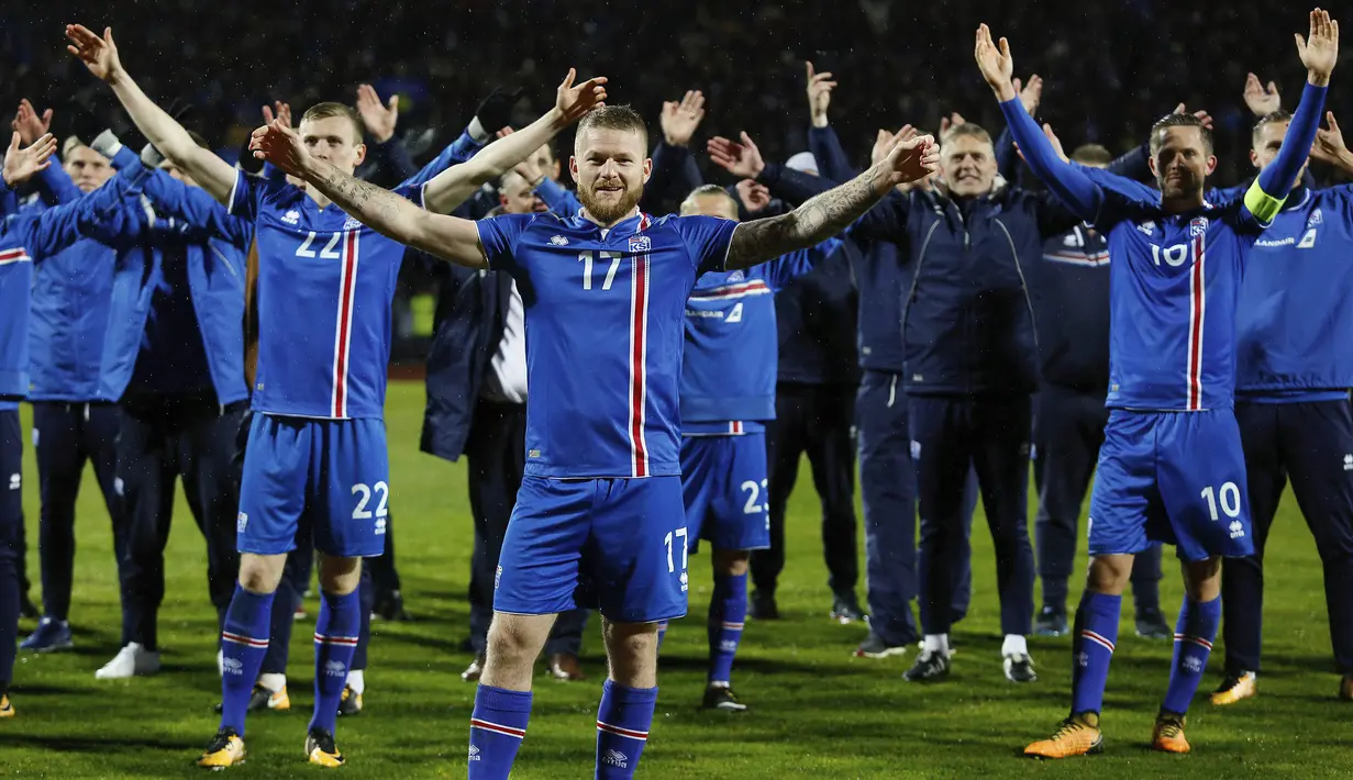 Kapten Islandia, Aron Gunnarsson, bersama rekan-rekannya merayakan keberhasilan lolos ke Piala Dunia 2018 usai mengalahkan Kosovo di Reykjavik, Senin (9/10/2017). Islandia untuk pertama kali dalam sejarah lolos ke Piala Dunia. (AP/Brynjar Gunnarsson)