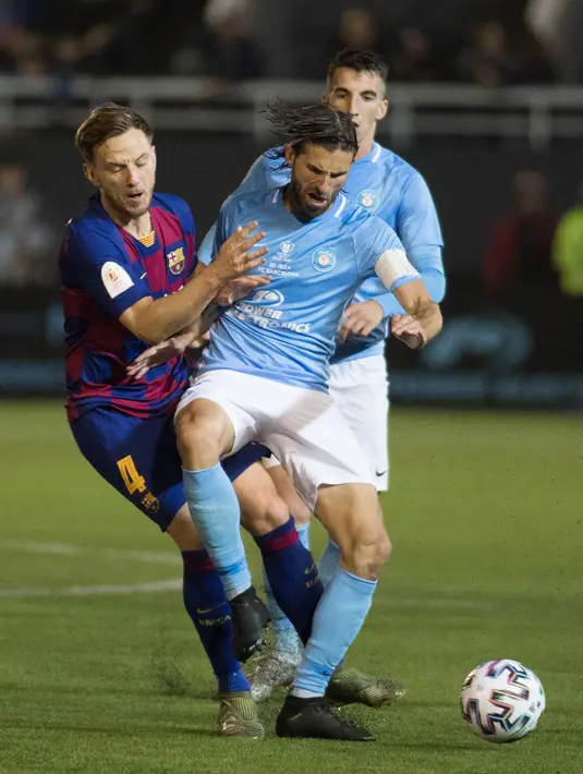 Gelandang Barcelona, Ivan Rakitic berebut bola dengan bek UD Ibiza, Gonzalo de la Fuente pada pertandingan babak 32 besar Copa del Rey 2019-2020 di Estadi Municipal de Can Misses, Rabu (21/1/2020). Barcelona harus bersusah payah untuk mengalahkan Klub Segunda B UD Ibiza 2-1. (JAIME REINA/AFP)