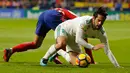 Pemain Real Madrid, Isco dan pemain Atletico Madrid, Lucas terjatuh saat pertandingan pekan ke-12 Divisi Primera La Liga Spanyol di Stadion Wanda Metropolitano, Sabtu (18/11). Laga Derbi Madrid itu berakhir imbang tanpa gol. (AP/Paul White)