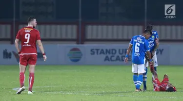 Pemain Persib, Tony Sucipto dan Bojan Malisic menolong pemain Persija yang cedera saat laga lanjutan Go-Jek Liga 1 Indonesia 2018 bersama Bukalapak di Lapangan PTIK, Jakarta, Sabtu (30/6). Laga dimenangkan Persija 1-0. (Liputan6.com/Helmi Fithriansyah)