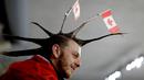 Seorang pria menata rambutnya dengan unik saat menyaksikan cabang curling antara Rusia dan Swiss pada Olimpiade Musim Dingin 2018 di Gangneung, Korea Selatan, Senin (12/2). Ada 92 negara peserta yang mengikuti ajang tersebut. (AP/Natacha Pisarenko)