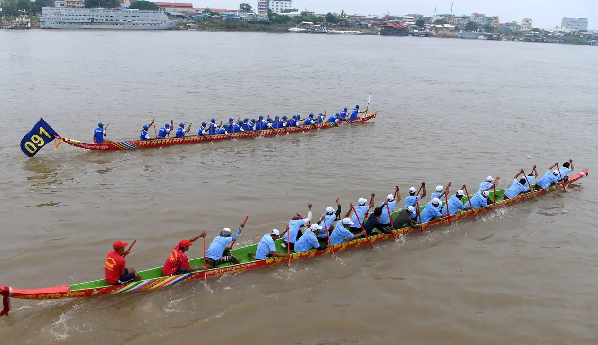 Peserta mendayung perahu naga menuju garis finish selama Festival Air di sungai Tonle Sap, Phnom Penh, Senin (11/11/2019). Cambodian Water Festival atau Bon Om Touk yang digelar pada 10-12 November ini merupakan salah satu festival terbesar dan paling populer di Kamboja. (TANG CHHIN Sothy/AFP)
