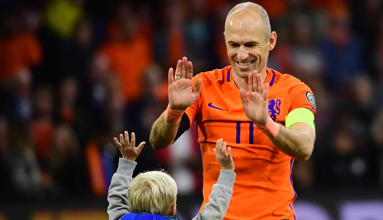 Gelandang Belanda, Arjen Robben bersama anaknya usai pertandingan melawan Swedia pada kualifikasi Piala Dunia 2018 di stadion Arena, Amsterdam (10/10). Dua gol yang dicetak Robben gagal mengantar Der Oranje lolos. (AFP Photo/Emmanuel Dunand)