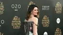 Anne Hathaway segera berpose didepan kamera paparazi yang berhasil meliput premiere filmnya. (AFP/Bintang.com)