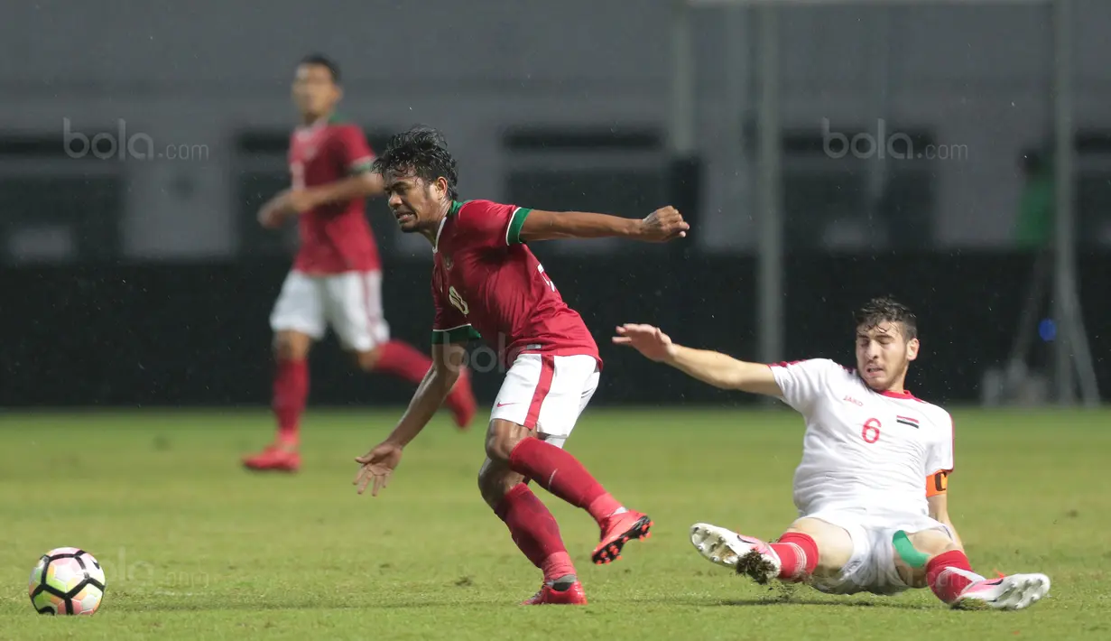 Pemain Timnas Indonesia U-23, Ilham Udin melewati adangan pemain Suriah U-23, Ahmad Askhar pada laga persahabatan di Stadion Wibawa Mukti, Bekasi, Rabu (16/11/2017). Indonesia kalah 2-3. (Bola.com/NIcklas Hanoatubun)