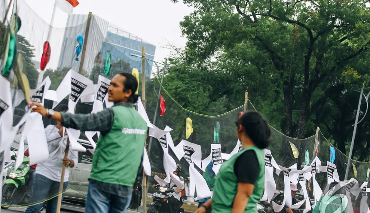 Para pendemo memasang atribut yang terbuat dari kertas berbentuk badan manusia saling bergandengan tangan di depan Istana Merdeka, Jakarta, Senin (27/10/2014) (Liputan6.com/Faizal Fanani)