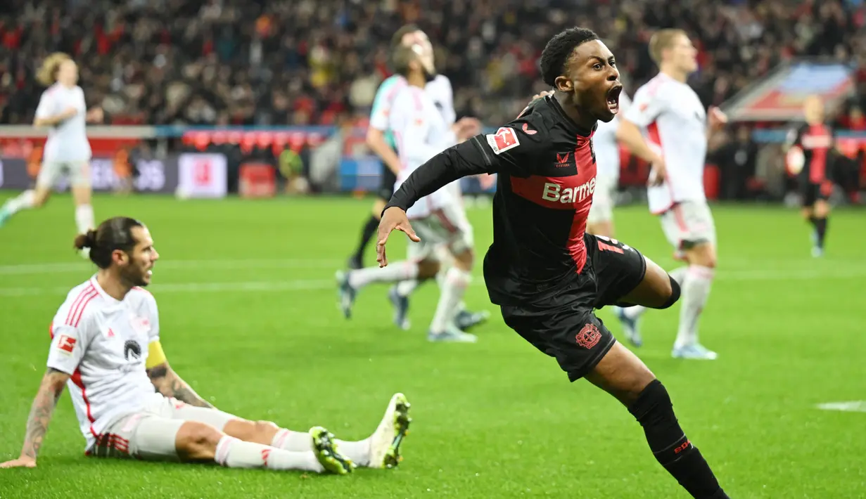 Pemain Bayer Leverkusen, Nathan Tella, melakukan selebrasi setelah mencetak gol ke gawang Union Berlin pada laga Bundesliga di Bay Arena, Minggu (12/11/2023). Leverkusen tampil beringas dengan menang empat gol tanpa balas atas Union Berlin. (AFP/Ina Fassbender)