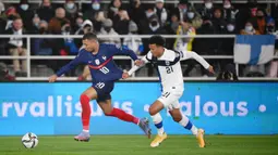Pemain Prancis Kylian Mbappe (kiri) dan pemain Finlandia Niko Hamalainen bersaing memperebutkan bola pada pertandingan sepak bola kualifikasi Grup D Piala Dunia 2022 di Stadion Olimpiade, Helsinki, Finlandia, 16 November 2021. Prancis menang 2-0. (FRANCK FIFE/AFP)