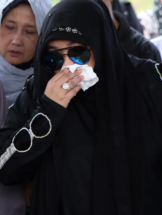 Iring-iringan jenazah tiba di Tempat Pemakaman Umum Tanah Kusir, Jakarta Selatan, pada Senin (23/5) sekitar pukul 09.30 WIB. Tampak raut kesedihan dari pasangan Rina Gunawan dan Teddy Syach. (Adrian Putra/Bintang.com)