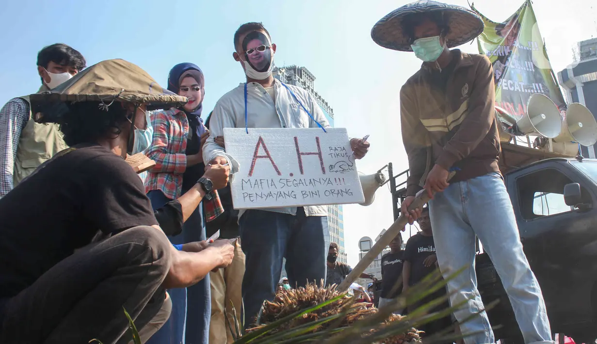Sejumlah massa yang tergabung dalam Barisan Masyarakat Anti Korupsi, Kolusi dan Nepotisme (BASMI KKN) melakukan aksi teatrikal di kawasan Patung Kuda, Jakarta, Jumat (27/5/2022). Mereka juga menuntut pemerintah untuk menyelesaikan kasus pemberian fasilitas ekspor Crude Palm Oil (CPO). (Liputan6.com/Herman Zakharia)