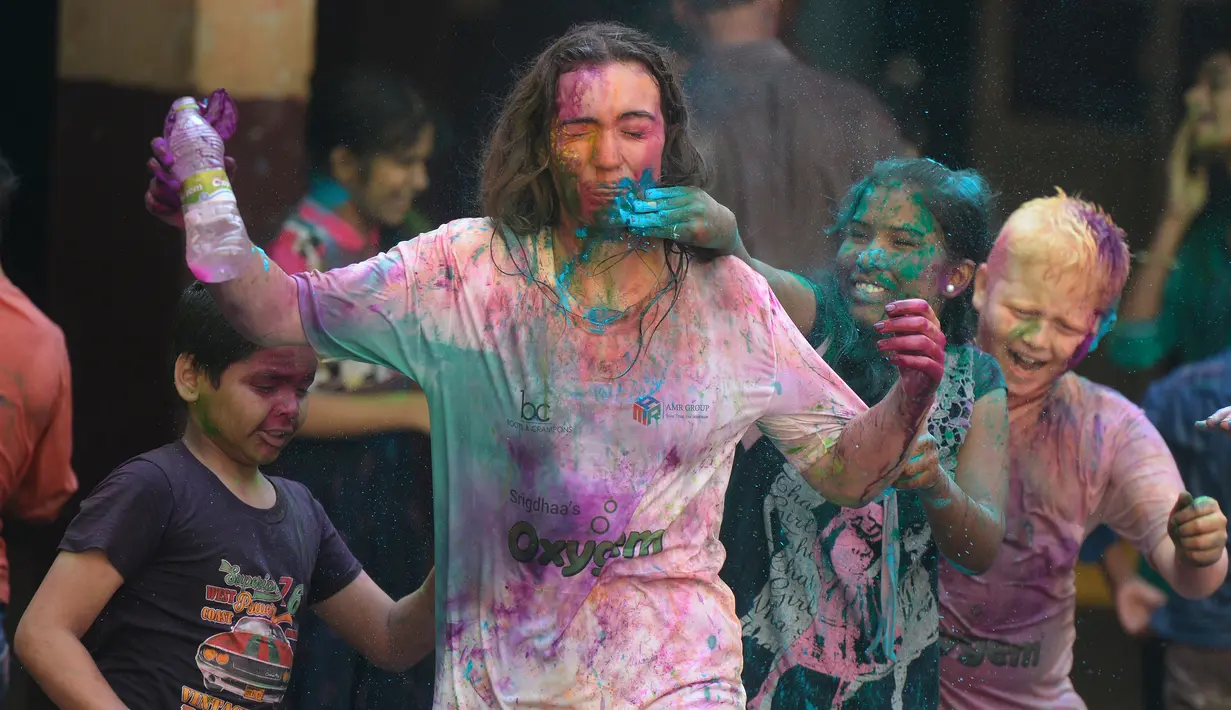 Murid-murid India  yang tunanetra dari The Devnar School for the Blind memberikan bubuk warna pada seorang guru ketika mereka merayakan festival Holi di Hyderabad, India (21/3). (AFP Photo/Noah Seelam)