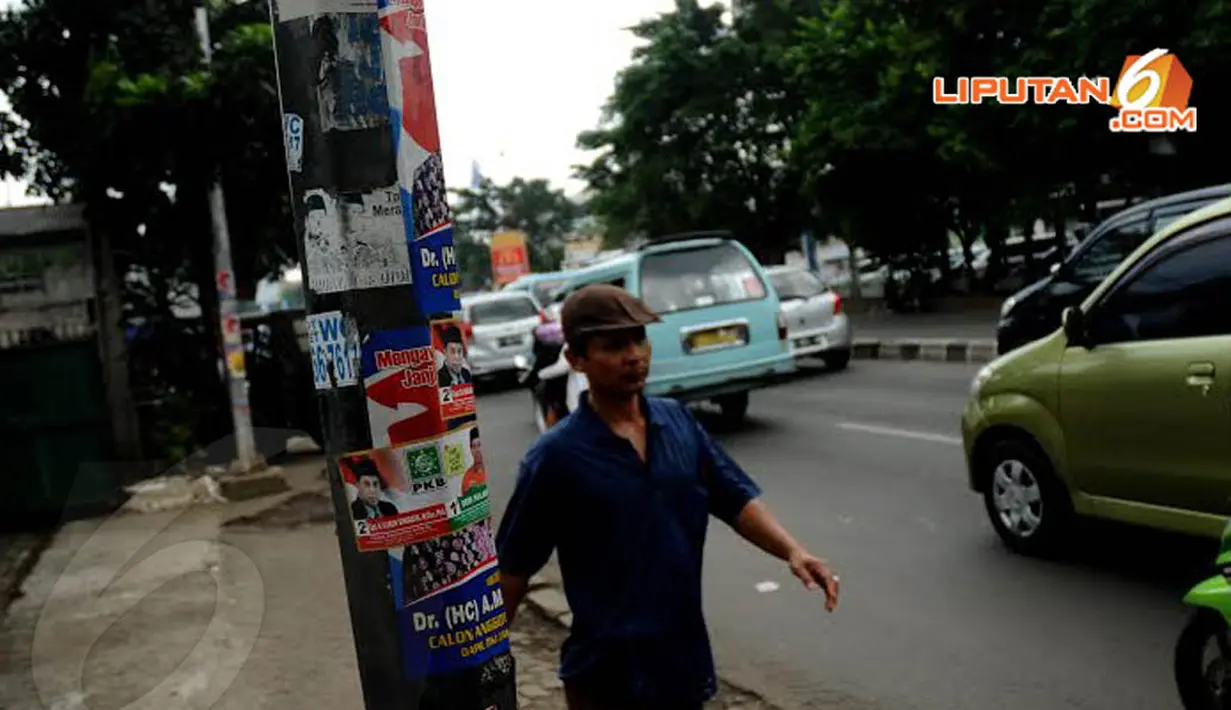 Sebuah tiang listrik di Jalan Raya Pasar Minggu terlihat dipenuhi tempelan stiker para politisi (Liputan6.com/Helmi Fithriansyah) 