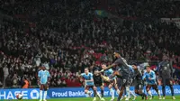 Striker Timnas Inggris, Ivan Toney mencetak gol dari titik putih saat laga uji coba internasional melawan Belgia di Wembley, Rabu (27/3/2024) dini hari WIB. (Adrian DENNIS / AFP)