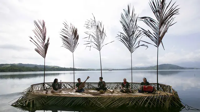 Para musisi tampil di tengah masyarakat dan keindahan panorama alam kampung Puai di tepi Danau Sentani, Papua.