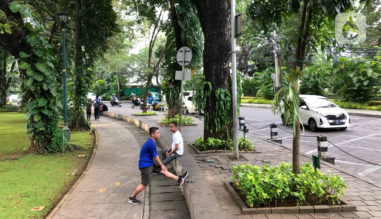 Warga beraktivitas di Taman Suropati, Menteng, Jakarta, Rabu (18/3/2020). Meskipun ditutup untuk umum terkait upaya mencegah penyebaran virus covid 19, namun sebagian masyarakat tetap beraktivitas di sekitar taman tersebut untuk berolahraga atau sekadar berekreasi. (Liputan6.com/Immanuel Antonius)
