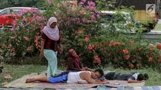 Pemudik memanfaatkan jasa terapis pijat dadakan dari warga sekitar di rest area Tol Palimanan - Kanci, Cirebon, Jawa Barat, Sabtu (1/7). Selama lebaran warga sekitar memanfaatkan arus balik dengan menyediakan jasa pijat. (Liputan6.com/Faizal Fanani)